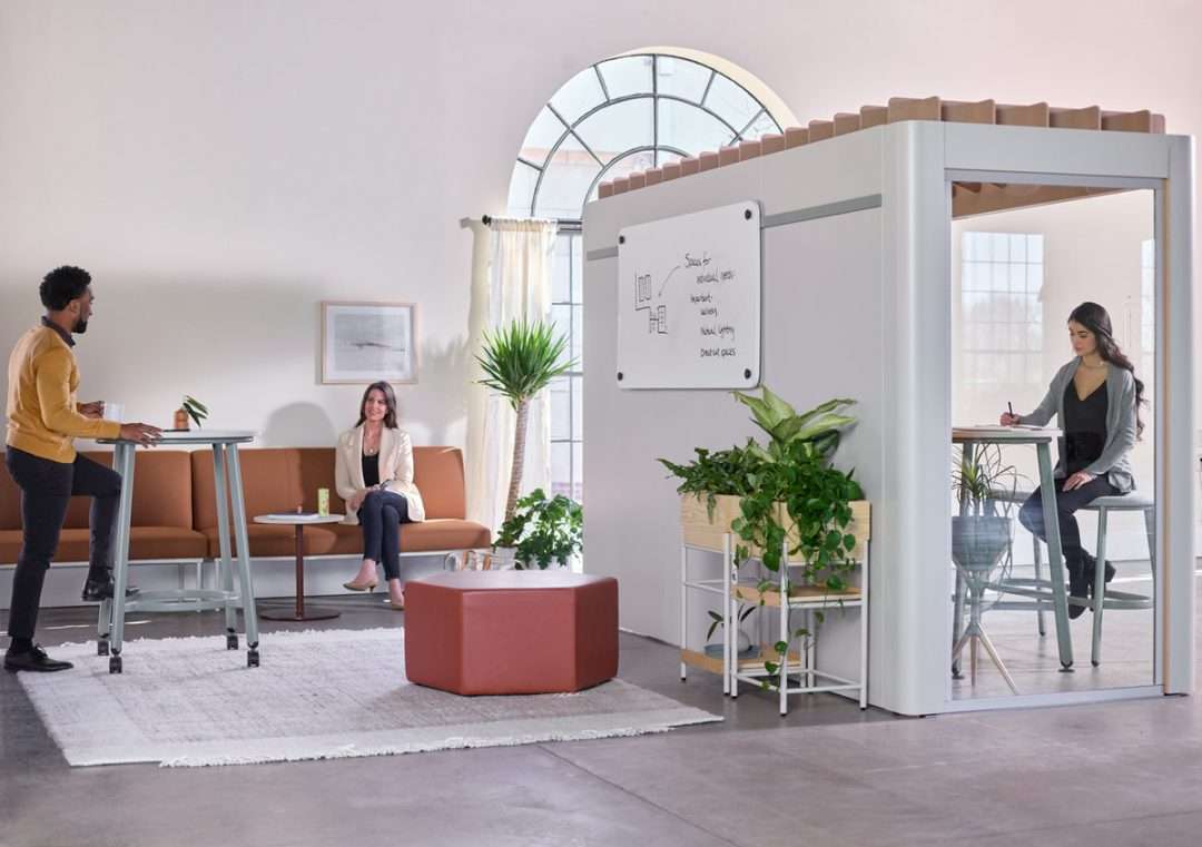 Modern office is broken into zones with cubicles in one area and a relaxed coworking space in another.